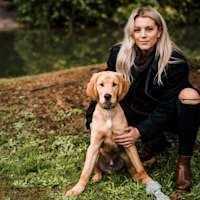 Woman with ripped jeans and Golden Retriever puppy