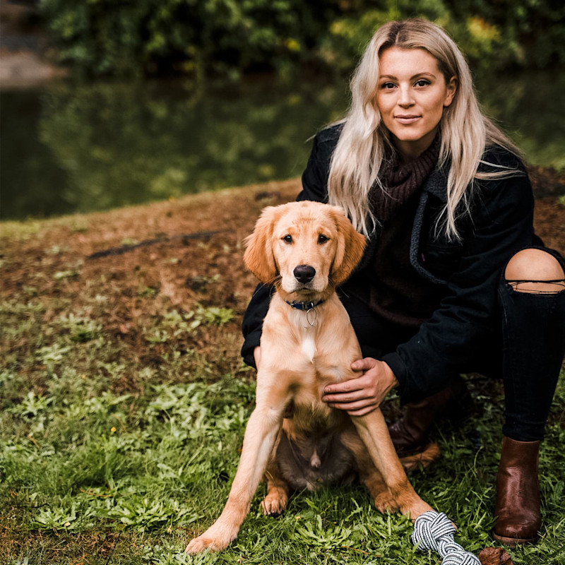 Woman with ripped jeans and Golden Retriever puppy
