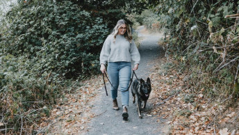 Black dog going for a walk with pet parent in leafy area