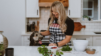 Woman cooking with dog in the kitchen