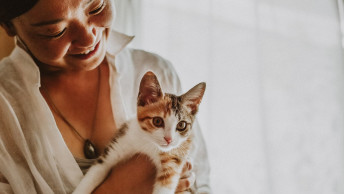 Woman holding calico kitten