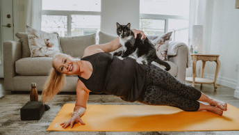 Shelley in yoga plank pose with black and white cat