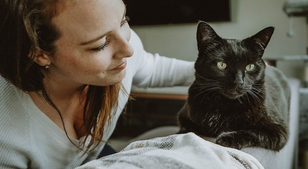 Woman with black cat on sofa