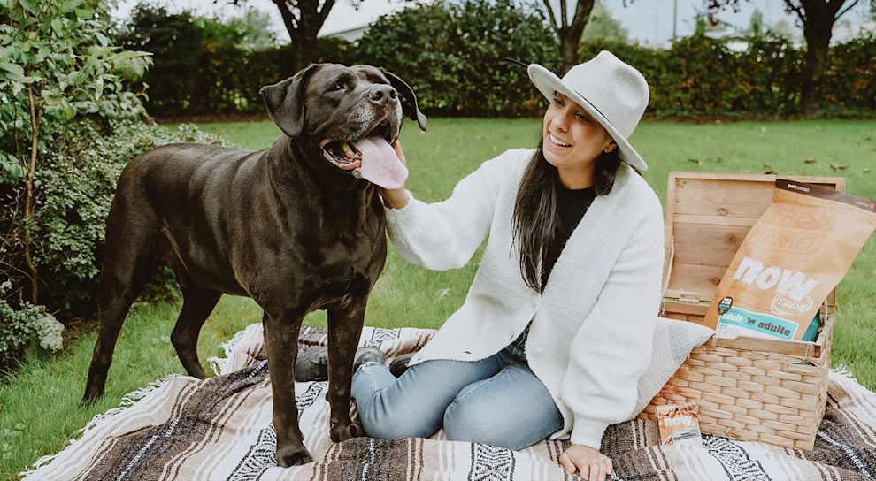 Woman and Chocolate Lab dog having a picnice