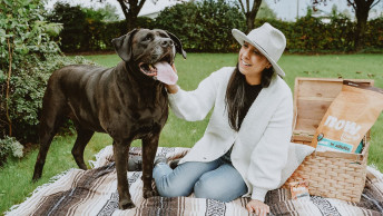 Woman and Chocolate Lab dog having a picnice