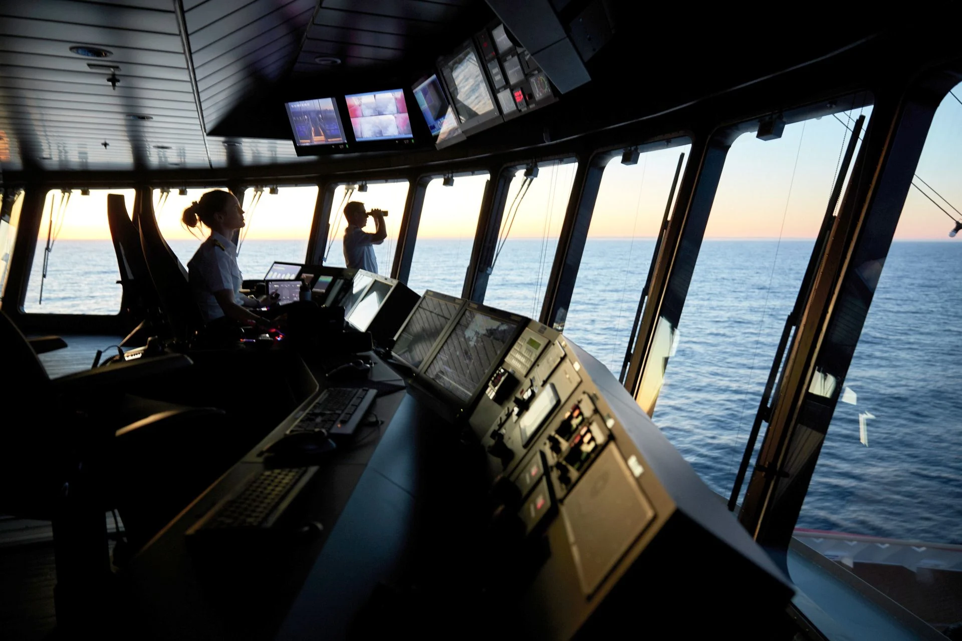 Crew on board MS Roald Amundsen scan the horizon at dawn.