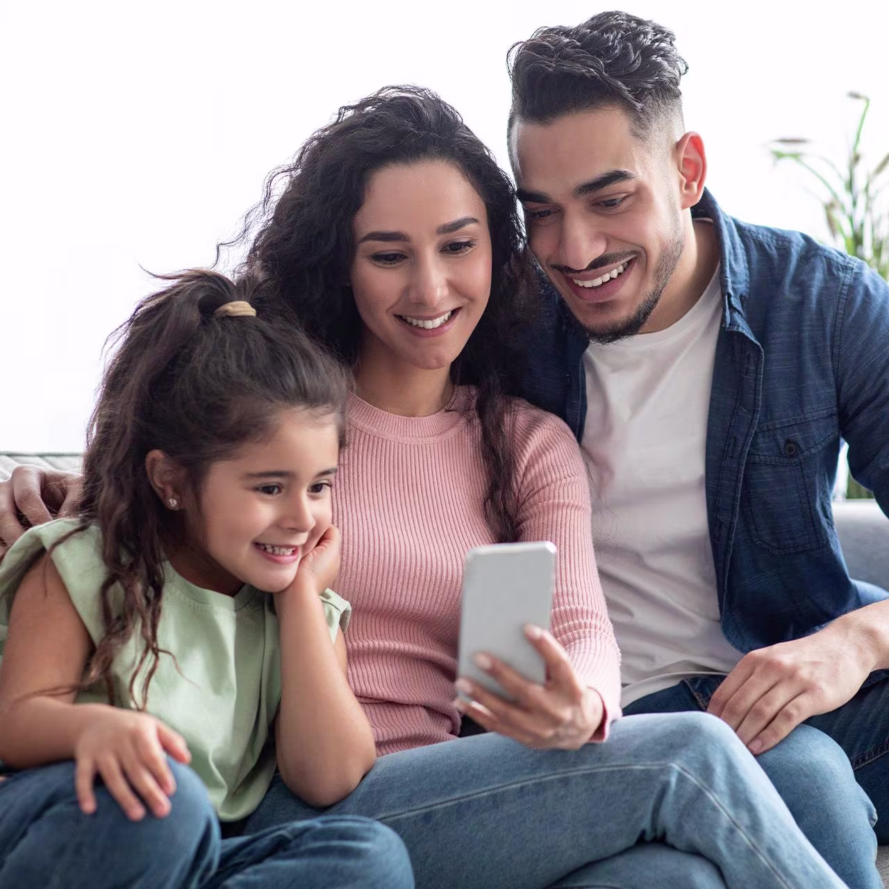 Morocco - How to pay for your transfer banner A photo of a Moroccan family of three smiling as they look at the smartphone screen
