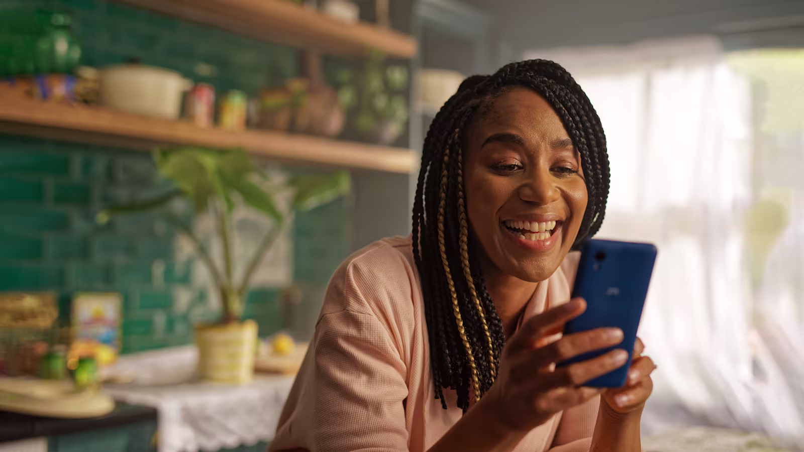 TV Commercial Still A woman looking at her phone and smiling