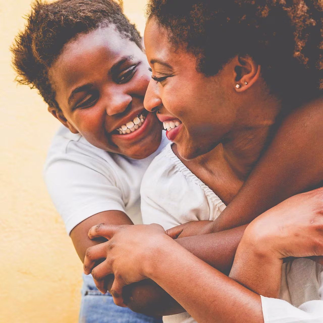 Two Africans, hugging and smiling