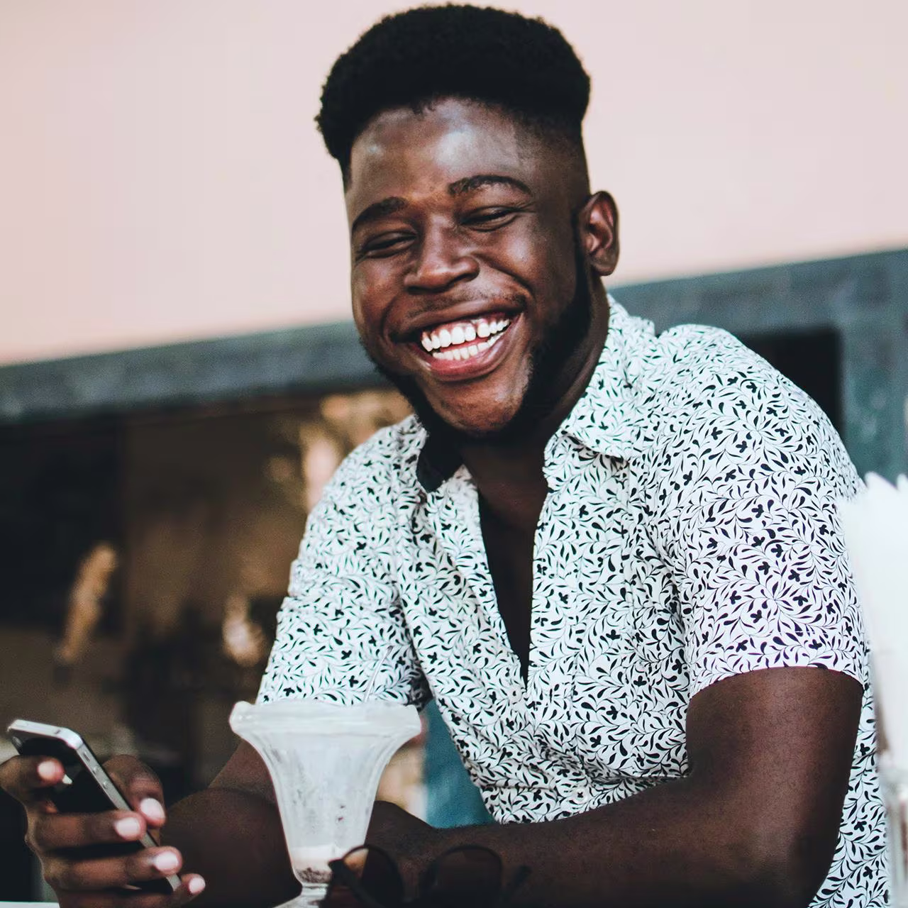 Zambia Zimbabwe - How to pay for your transfer banner An African man with his smartphone in his hand and smiling