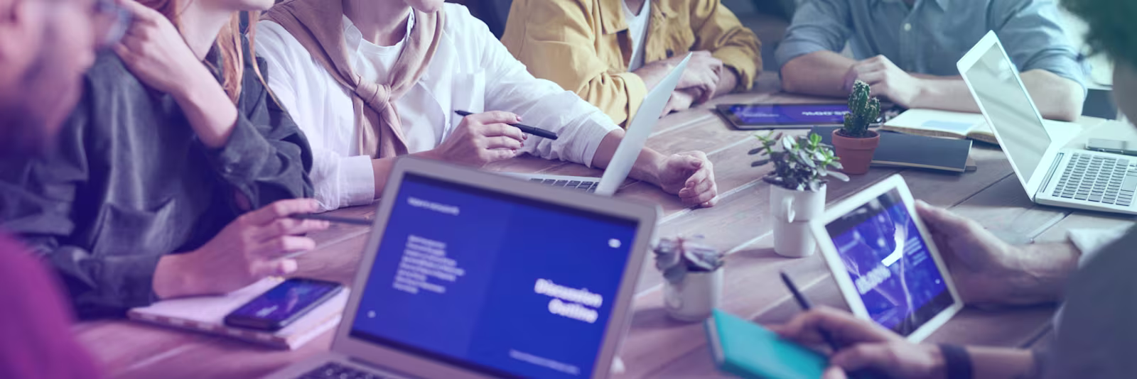 An image of people using their laptops and working at a table