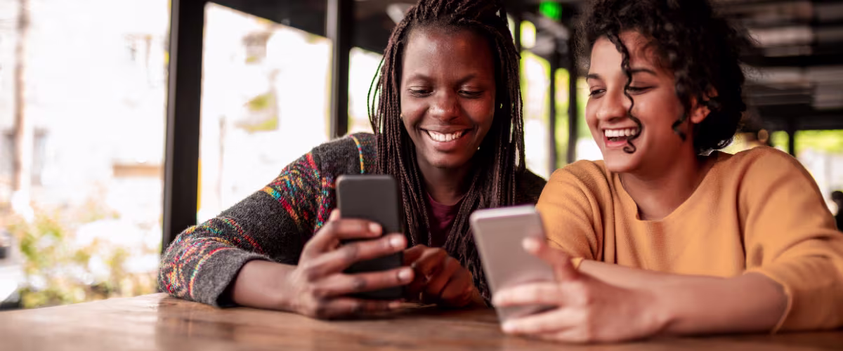 scenarios An image of two girls using their phones and smiling