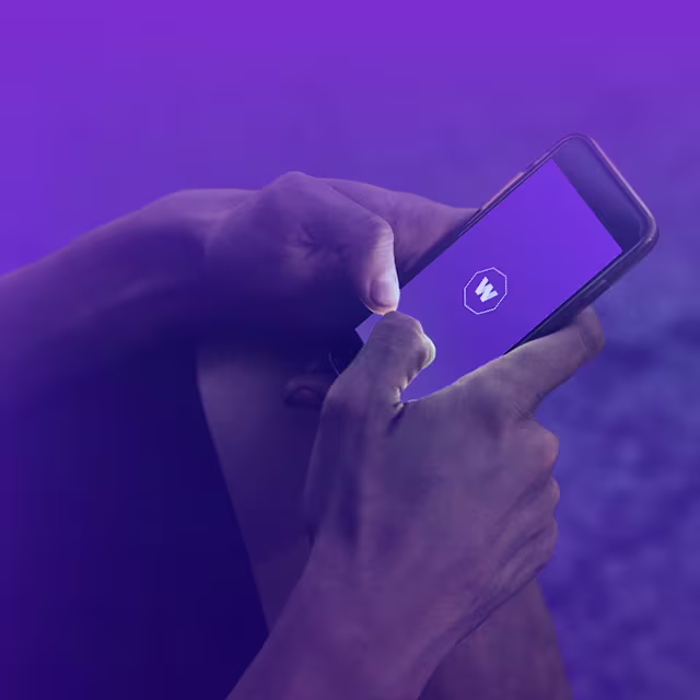 Promo Banner - Mobile A close-up image of the hands of someone holding a smartphone with the WorldRemit logo displayed