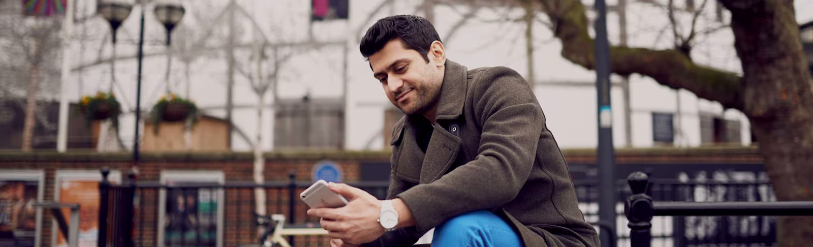 A banner photo of a man looking at a phone