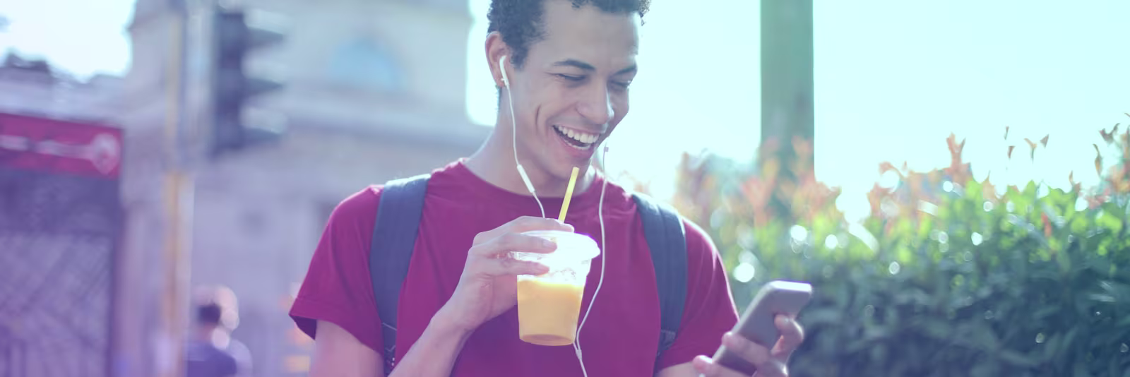 mobile-money-mobile-banking-header An image of someone drinking a drink and using their phone