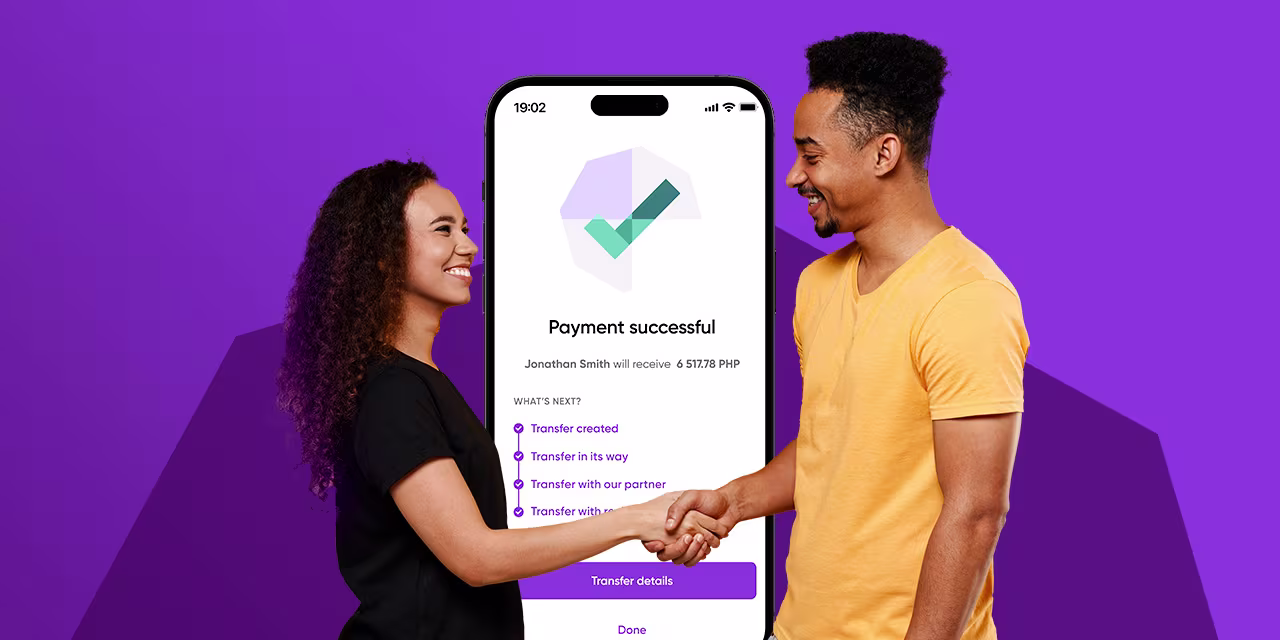 A man a woman shaking hands with a phone behind them displaying the payment successful screen of the WorldRemit app