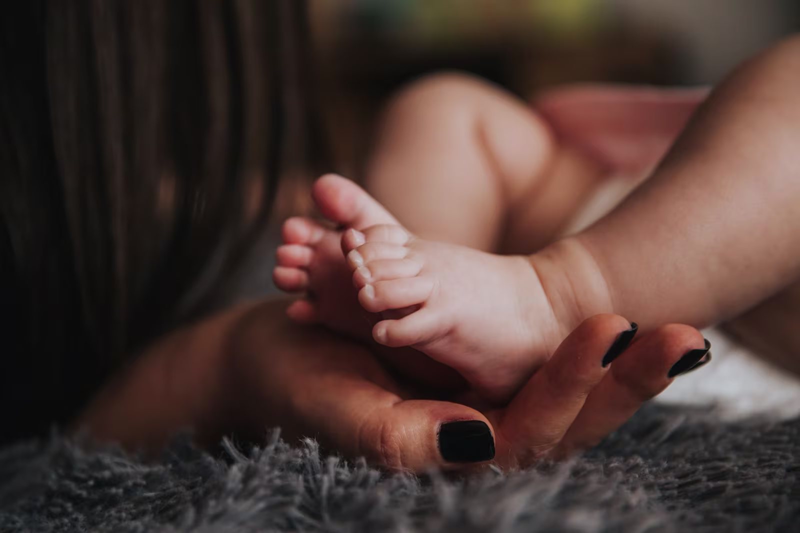 A close up of a baby's feet being held in a woman's hand