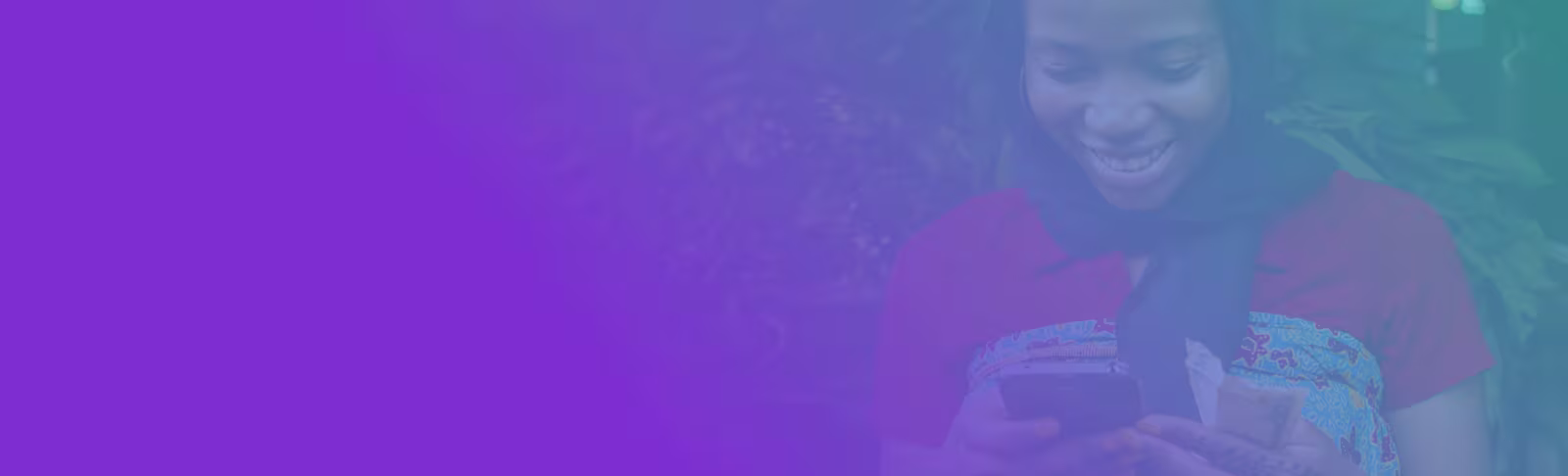 Global financial inclusion and exclusion A woman looking down at her phone and smiling with a purple tint over the image