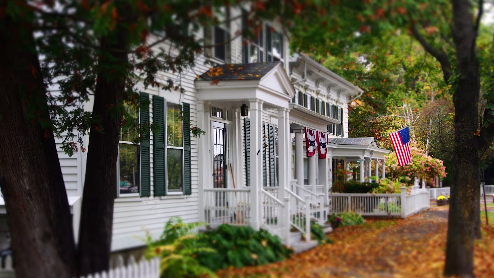 The outside of a house with the American flag hanging outside of it