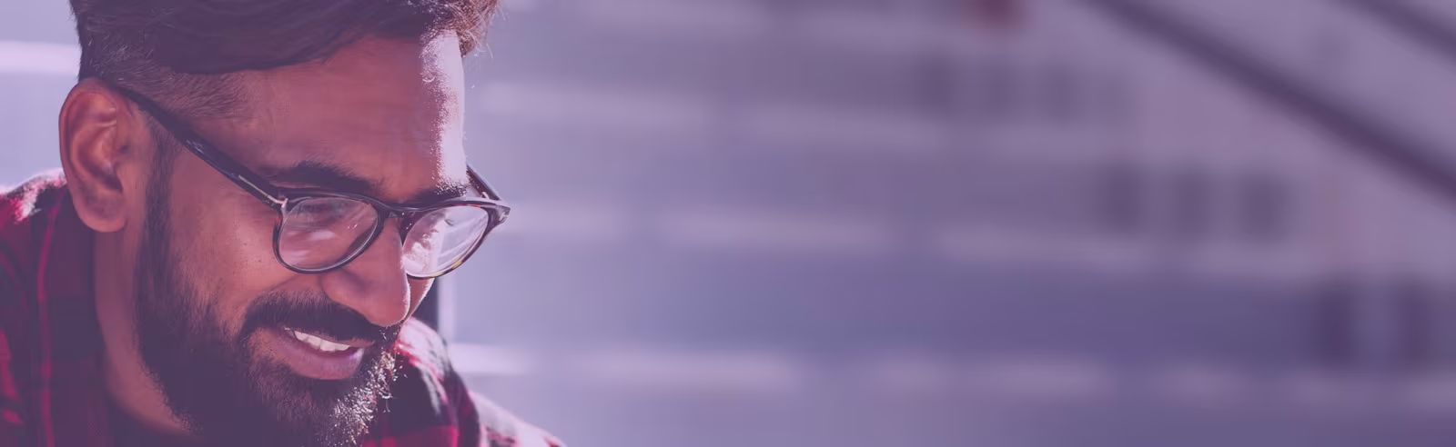 Fijian An image of a man sitting down, looking at his phone and smiling