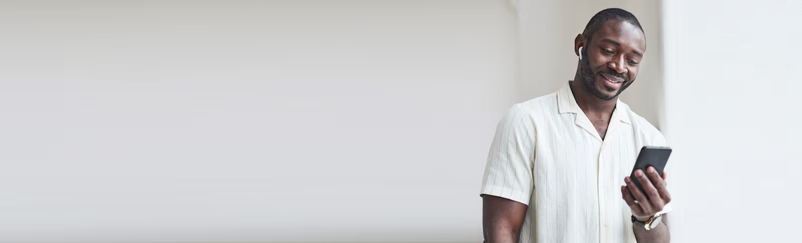 A grey banner, with a man to the right smiling and on his phone