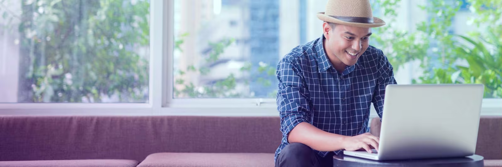 Man using his laptop A man using his laptop on a small side table
