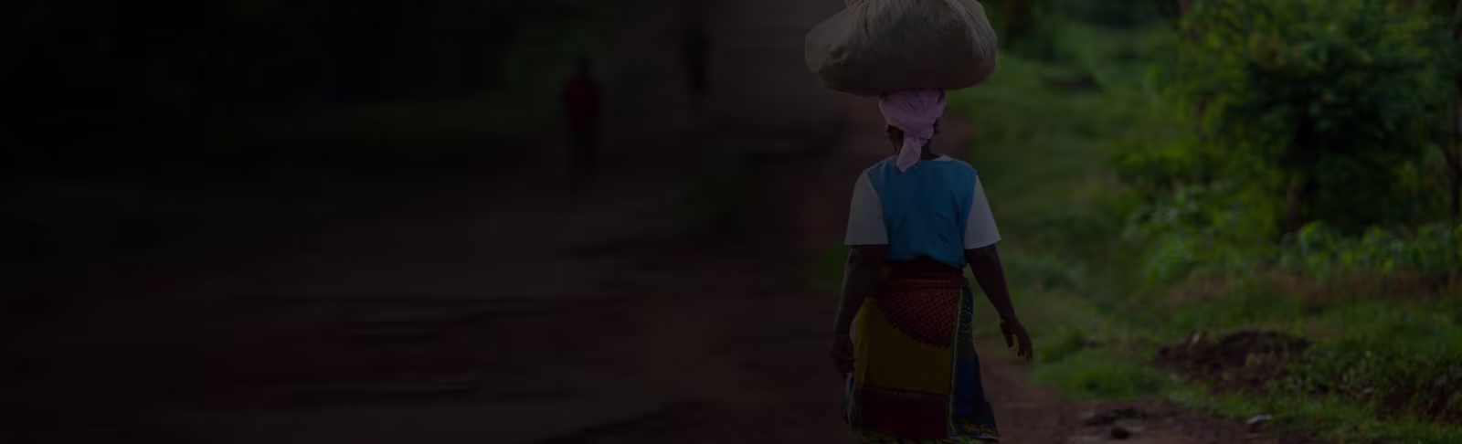 Carrying a lot of weight A photo of the back of a woman in Africa, carrying a heavy bag on her head