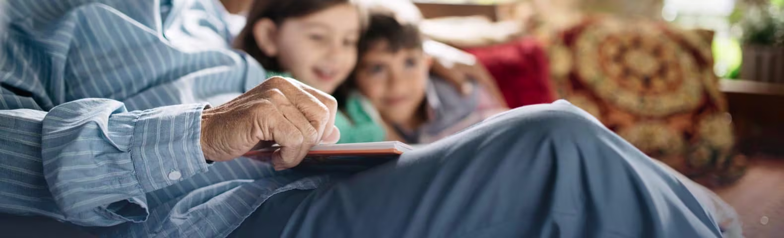 Grandfather reading a book to his grandchildren