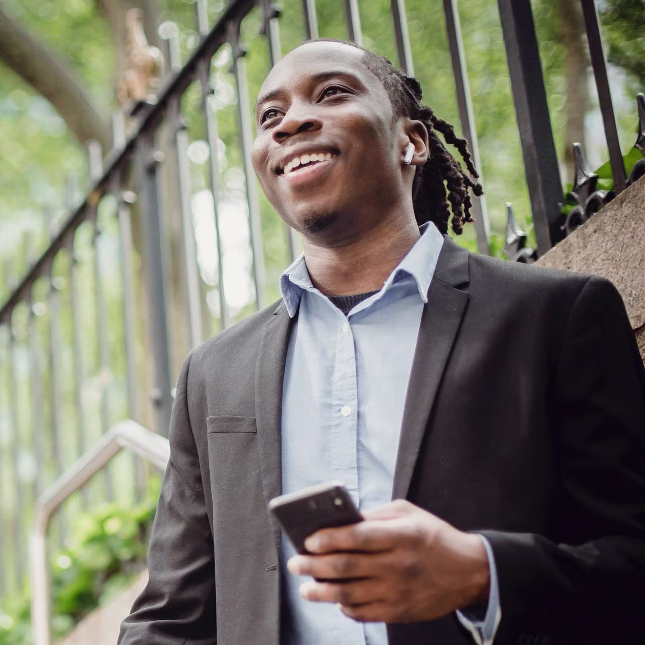 An African man smiling with his phone in his hand