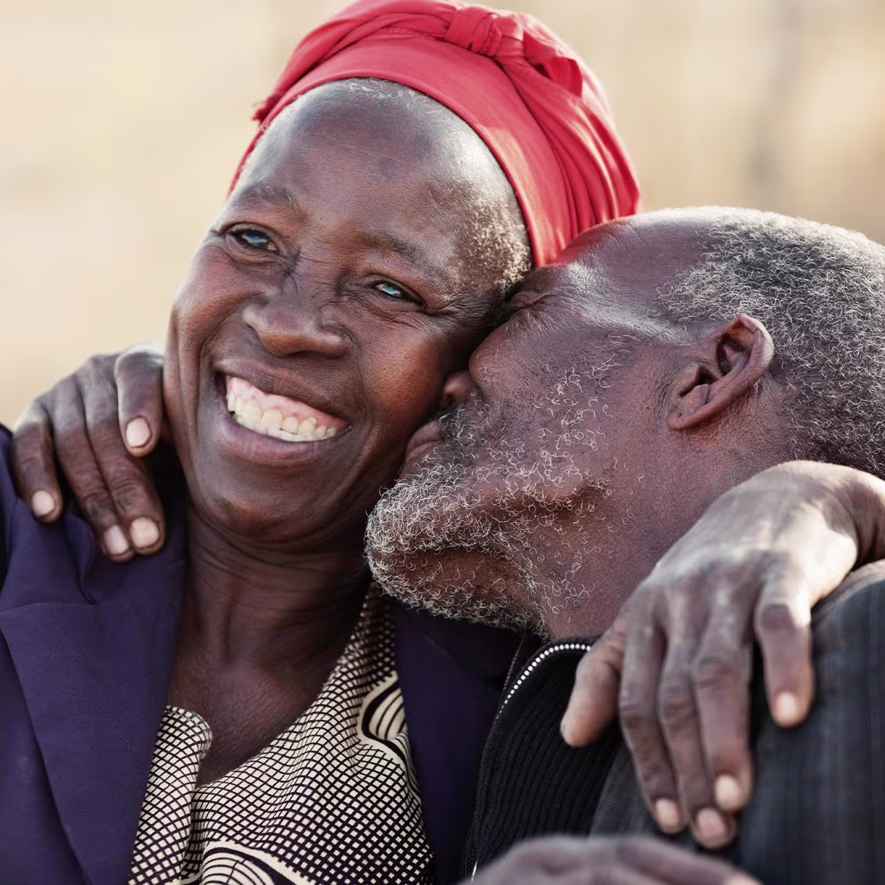Zambia Zimbabwe - How much does it cost to send money banner An African couple with their arms around each other and laughing