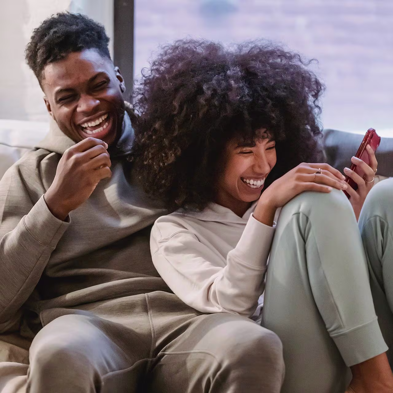 An African couple sat on the sofa and laughing