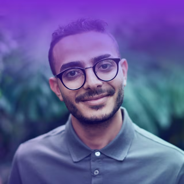 An image of a man with glasses smiling