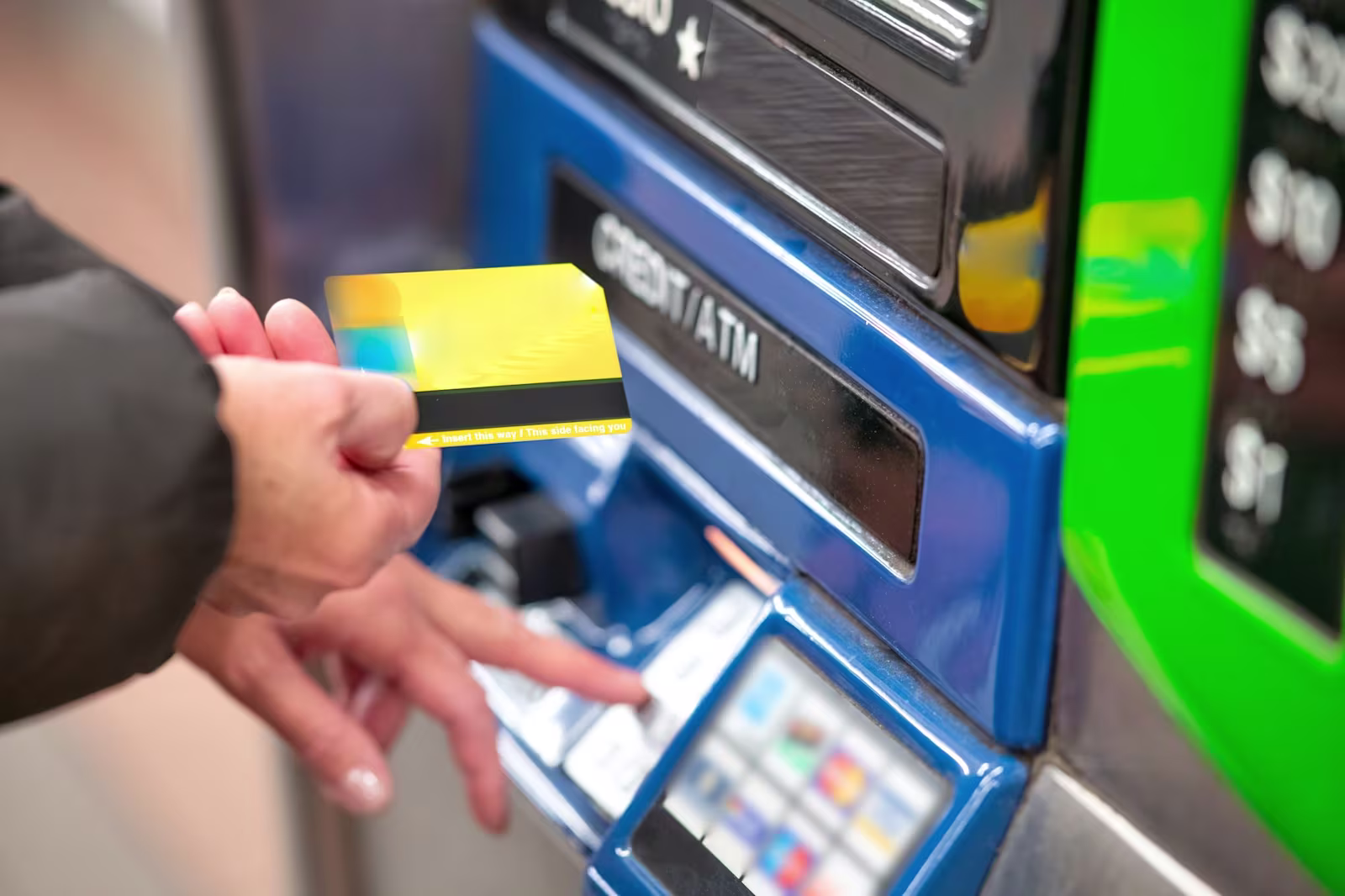 Mano introduciendo una tarjeta de crédito en un cajero automático Mano introduciendo una tarjeta de crédito en un cajero automático