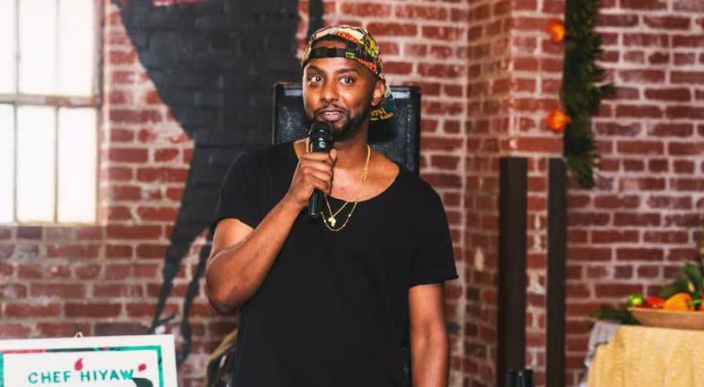 A photo of Hiyaw Gebreyohannes with a mic in his hand