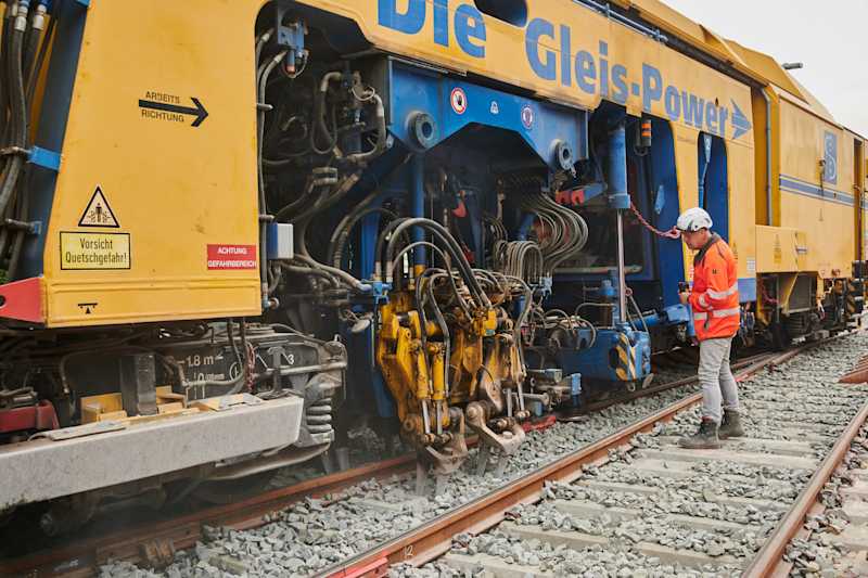 Eine Gleisstopfmaschine bearbeitet den Schotter auf der Riedbahn zwischen Frankfurt/Main und Mannheim. Quelle: Deutsche Bahn AG / Stefan Wildhirt 