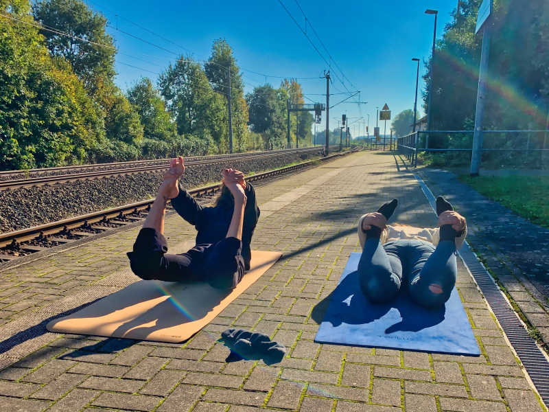 Zwei Frauen machen Yoga auf einem Bahnsteig