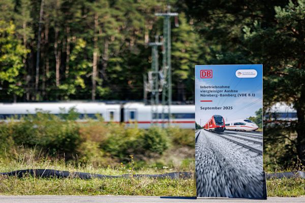 Ein Roll-Up zur Inbetriebnahme der Strecke Nürnberg-Bamberg steht vor einer Bahnstrecke mit ICE