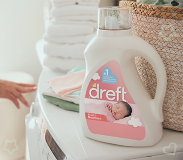 Dreft liquid detergent for getting food stains out of baby clothes on top of a washing machine
