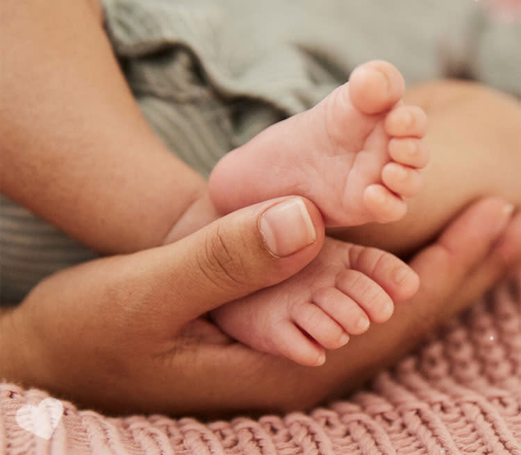 Woman holding baby's feets in her arms