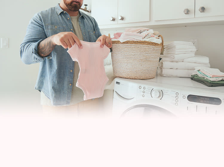 Man pulling out baby clothes from the basket