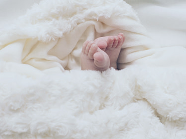 Children's feet covered with a soft blanket