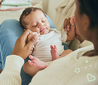 Woman with a baby on her legs holding him with her hands