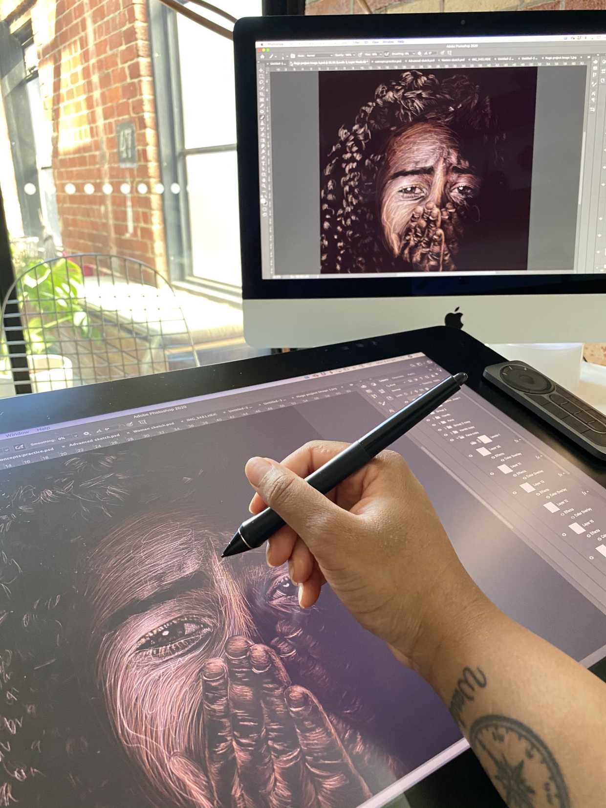 Artist Jessica Coppet works on her illustrated portrait of a little Black girl on her digital work pad.