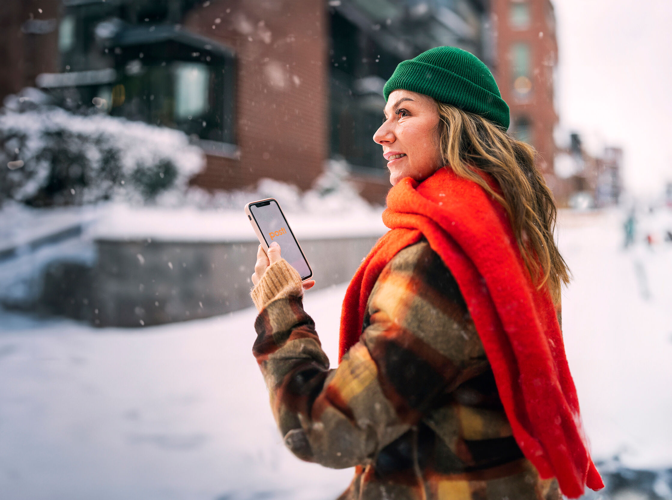 A woman with a phone in a winter landscape.