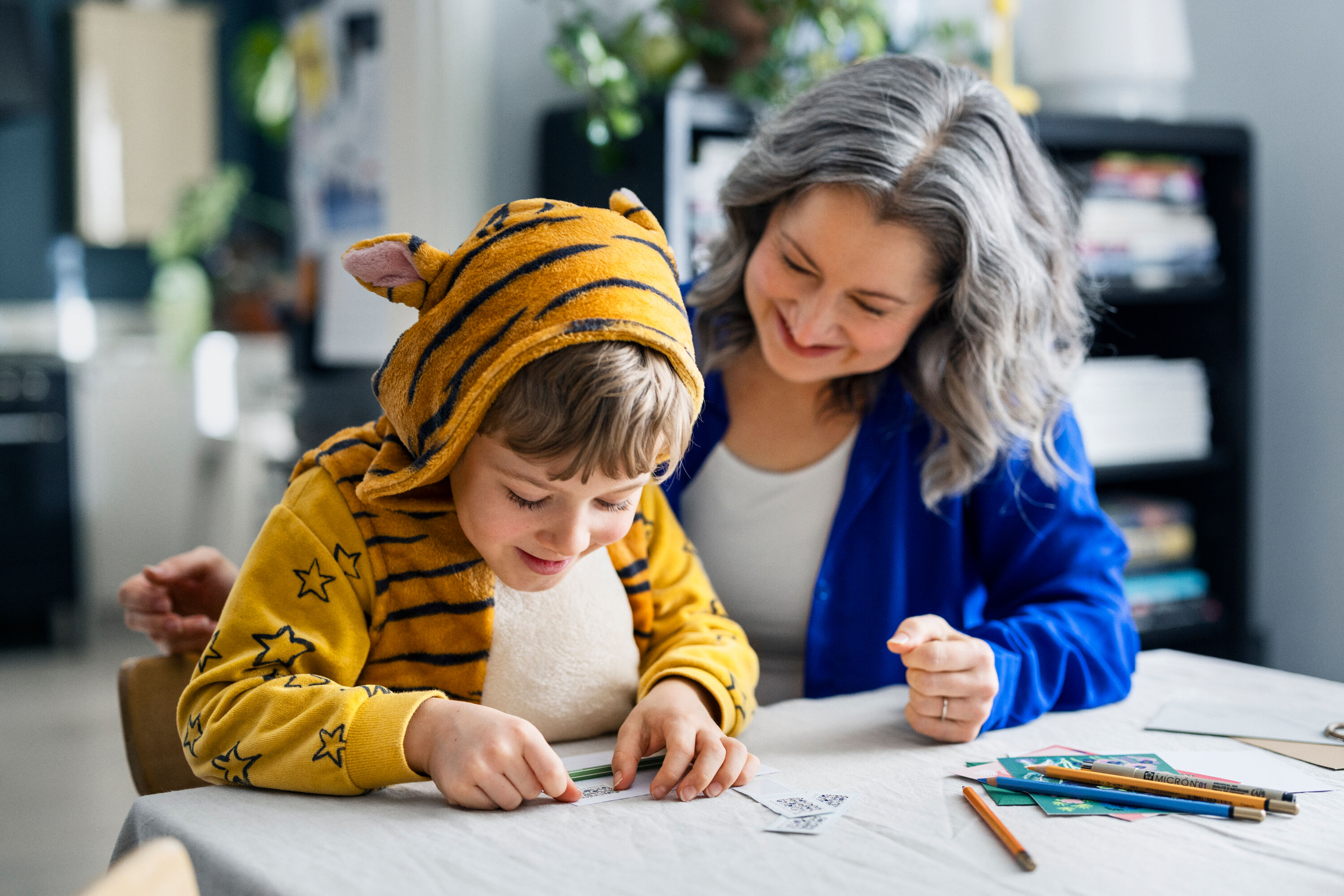 A child is putting a stamp on a letter.