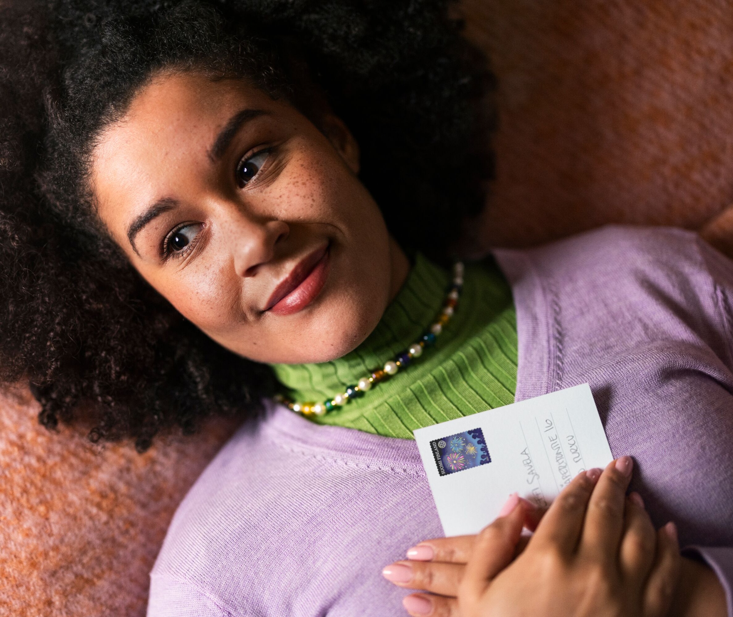 The woman is holding a postcard.