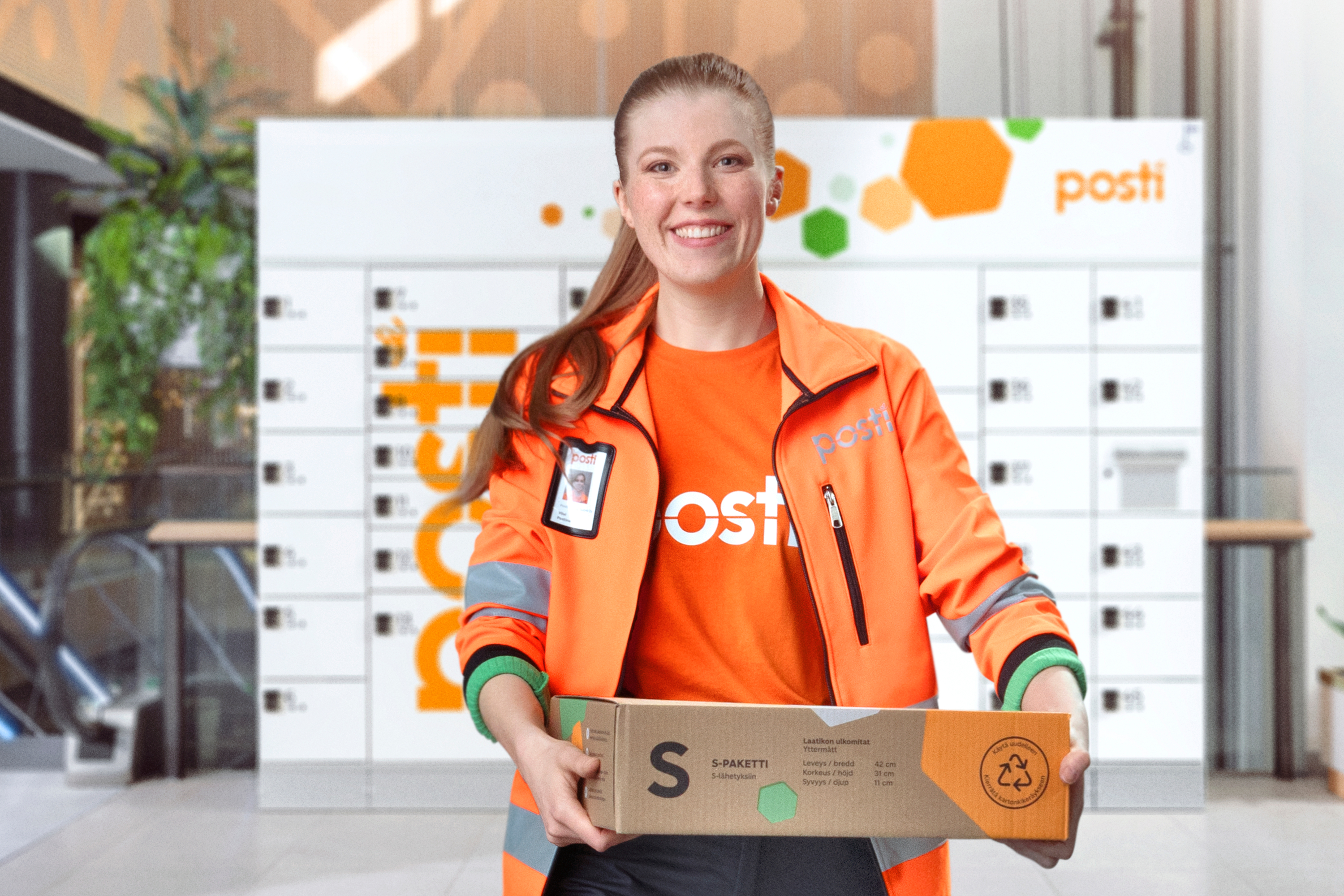 A smiling Posti employee at the Posti Parcel Locker.