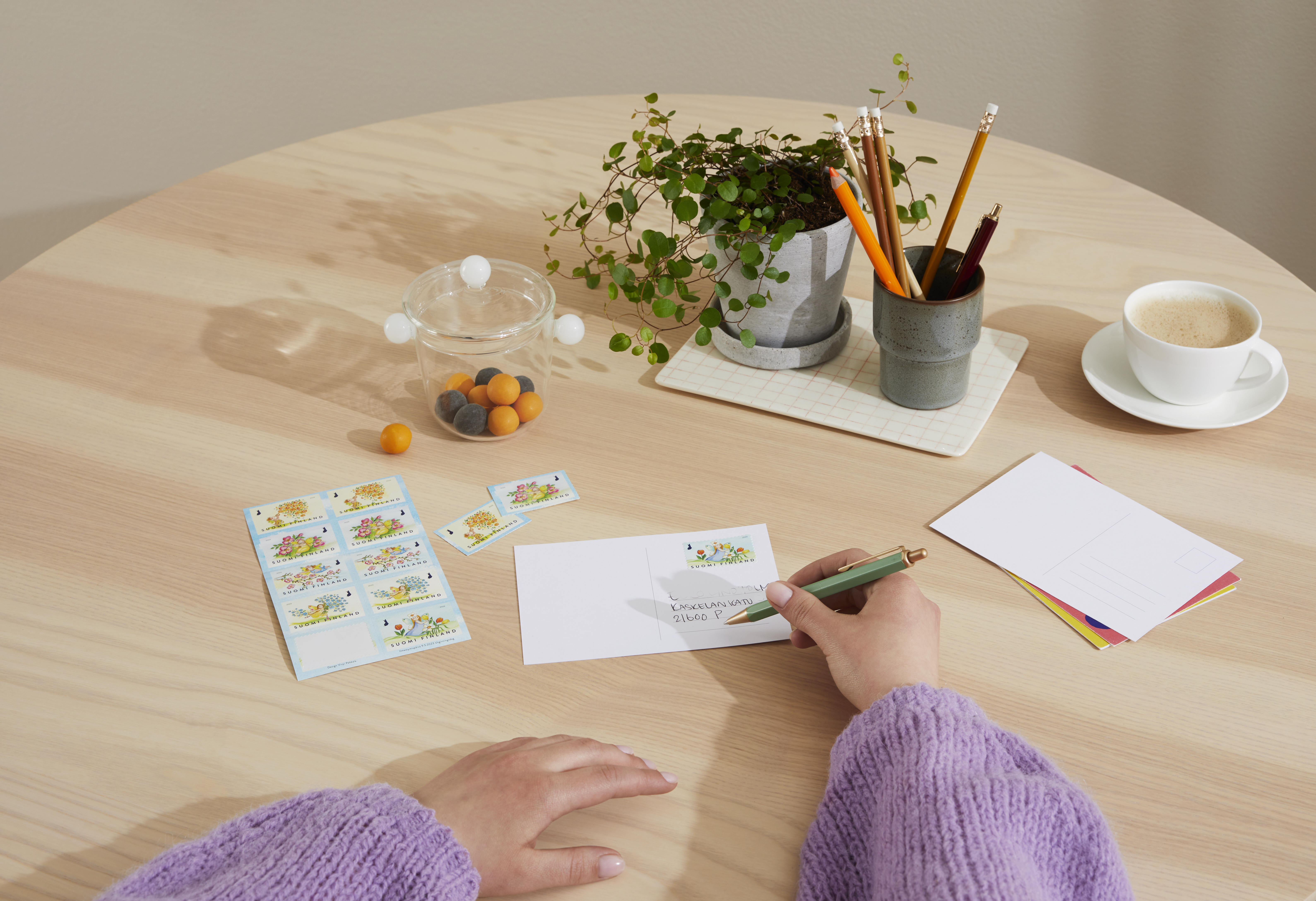 Postcards, stamps, and envelopes on a desk.