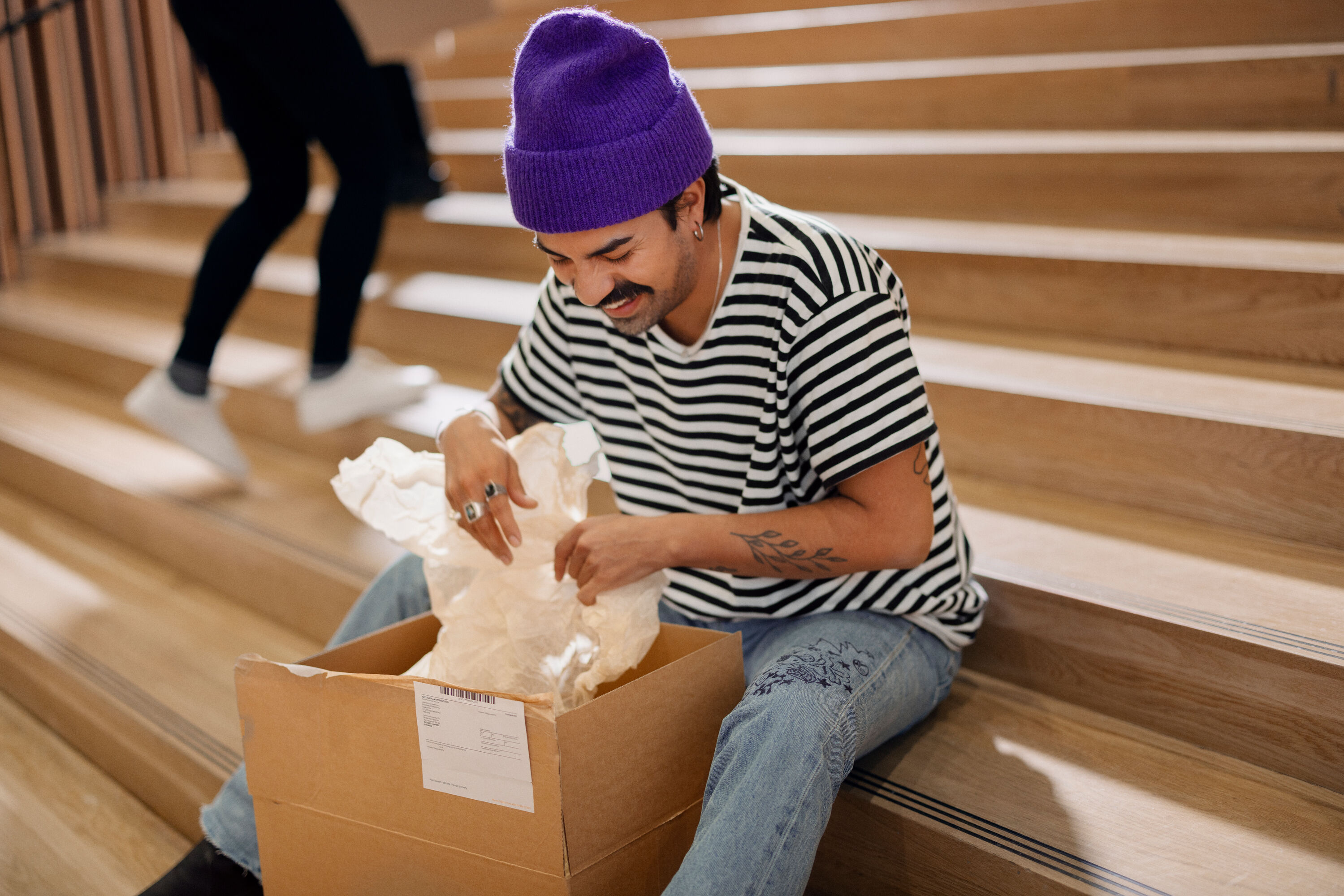 A delighted person opening a package.