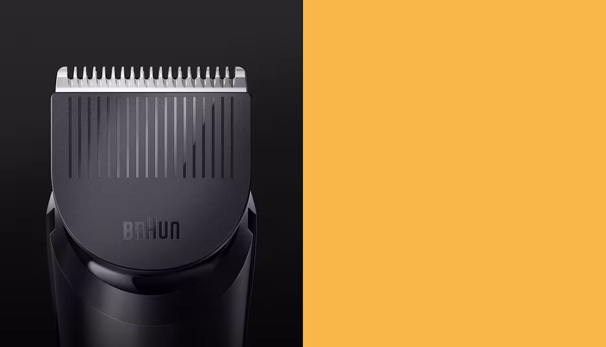 Braun black hair clipper close-up showing silver metal blade teeth and textured guard attachment Braun black hair clipper close-up showing silver metal blade teeth and textured guard attachment